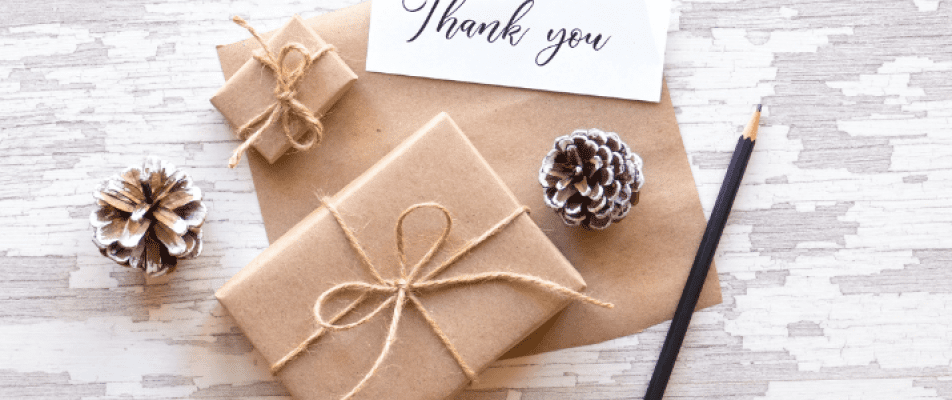 A close up of wrapped gifts with a note