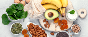 A table topped with avocados, bananas and almonds.