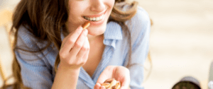 A woman holding nuts and smiling for the camera.