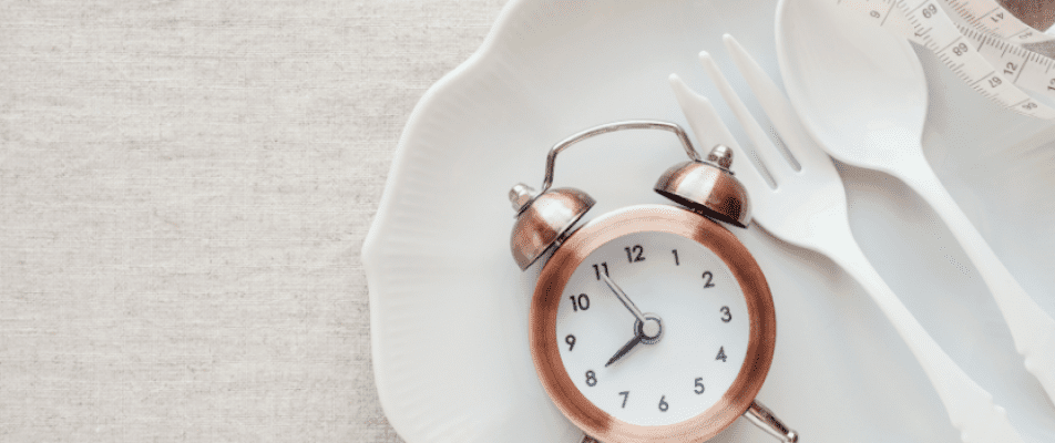 A close up of an alarm clock on top of a plate