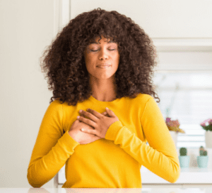 A woman with her hands over her chest.