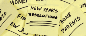 A yellow post it note with new year 's resolutions written on it.