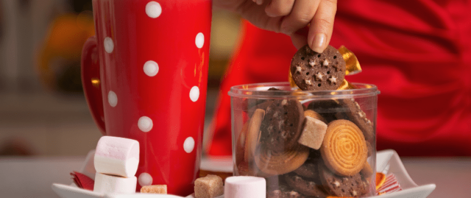 A person is putting cookies in a cup