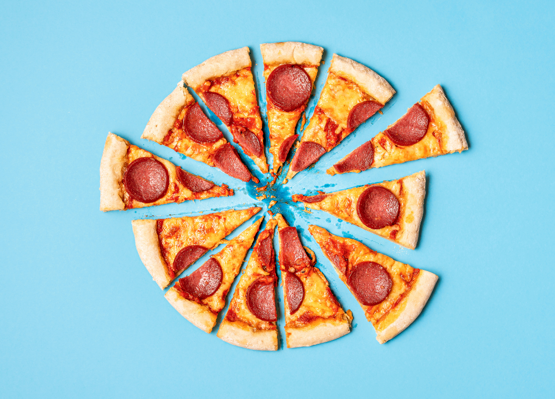 A pizza cut into eight pieces on top of a blue surface.