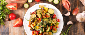 A white plate topped with vegetables on top of a wooden table.