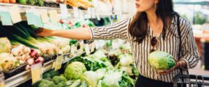 A woman is shopping in the produce section of a store.