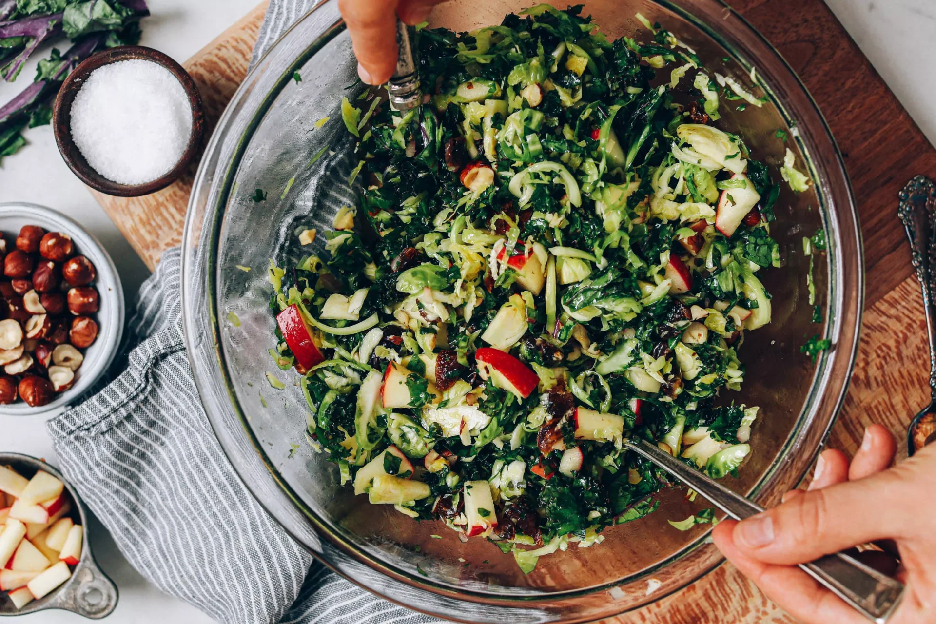 A person is holding a fork and salad in a bowl.