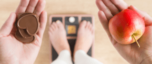 A person standing on their feet in front of a scale.