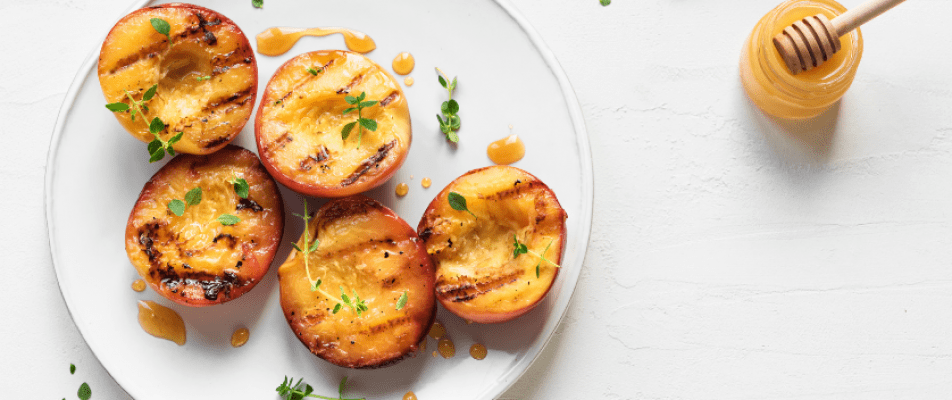 A plate of grilled peaches on top of the table.