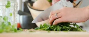 A person cutting vegetables with a knife.