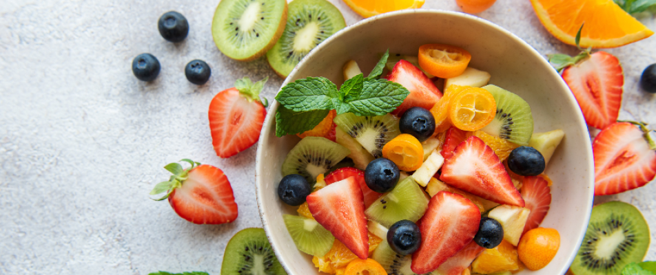 A bowl of fruit with strawberries, kiwi and blueberries.