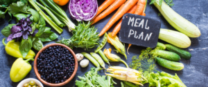 A table topped with carrots, beans and broccoli.