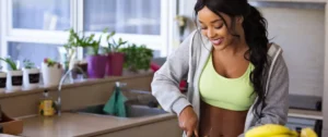 A woman in a green shirt is cutting food.