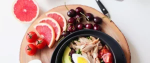 A bowl of food on top of a wooden board.