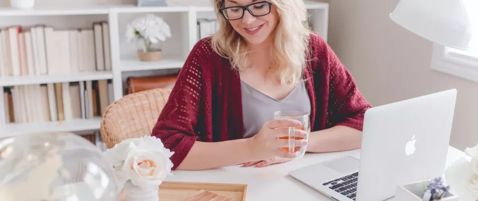 A woman sitting at a table with a glass of water.