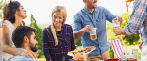 A man handing food to a woman at an outdoor party.