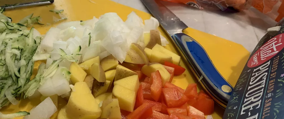 A knife and some cut up vegetables on a cutting board