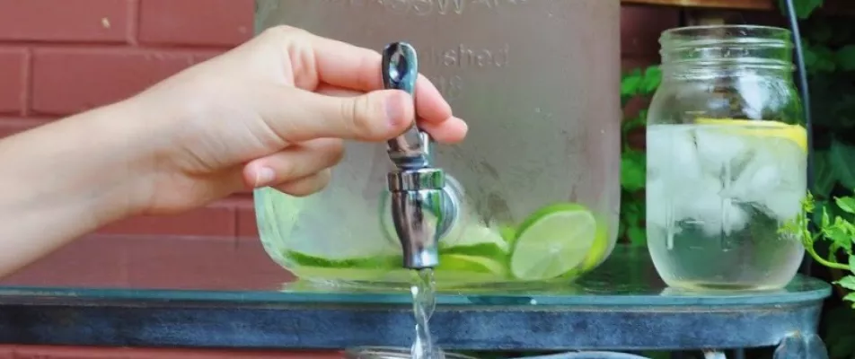 A person is pouring lime juice from a faucet.