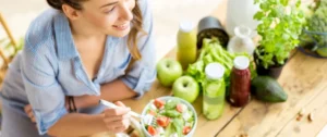 A woman sitting at the table with some food.